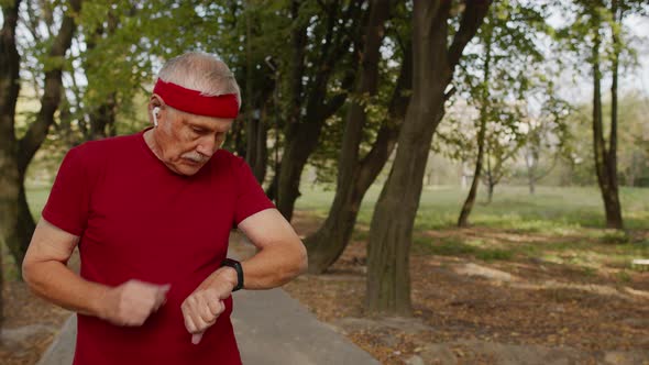 Elderly Sport Man Stops After Running, Using Smart Watch, Checking Heart Rate During Fitness