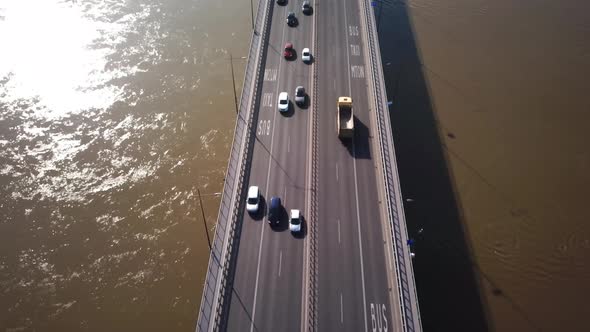 Aerial shot focuses on the traffic on the bridge. Cars driving. Cars crossing the bridge. 4K. Sun sh