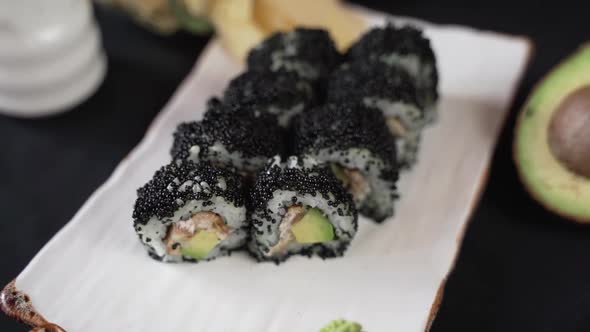 Top view of sushi roll with black caviar and avocado