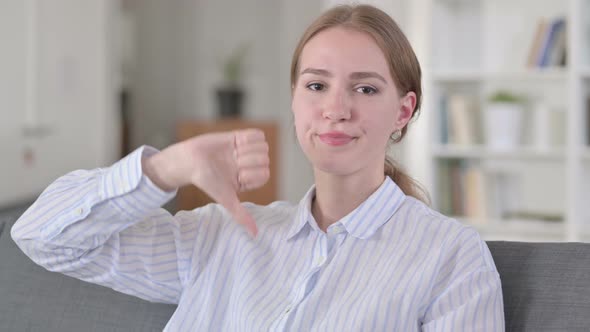 Portrait of Disappointed Young Woman Doing Thumbs Down 