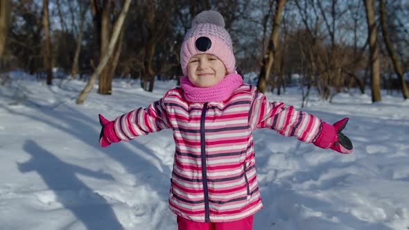 Smiling Child Kid Looking at Camera Embracing Fooling Around Hugging in Winter Snowy Park Forest