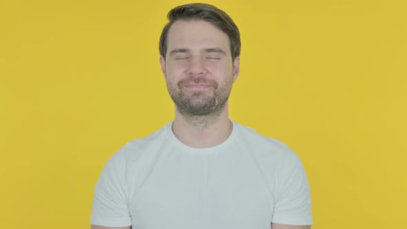 Young Man Shaking Head in Approval on Yellow Background