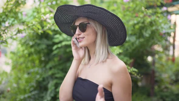 Young Stylish Beautiful Woman in Hat Using a Smart Phone