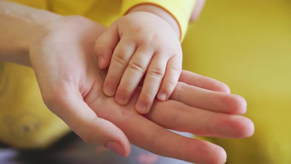 Close Up of Baby Touching Mother's Hand