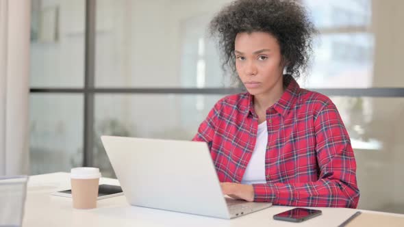 African Woman Feeling Shocked While Using Laptop in Caf�