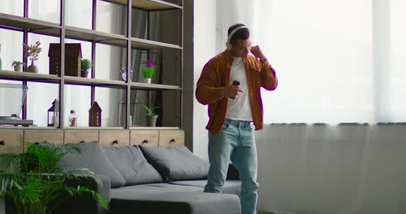 Young Latin Man Is Dancing in Wireless Headset in Living Room
