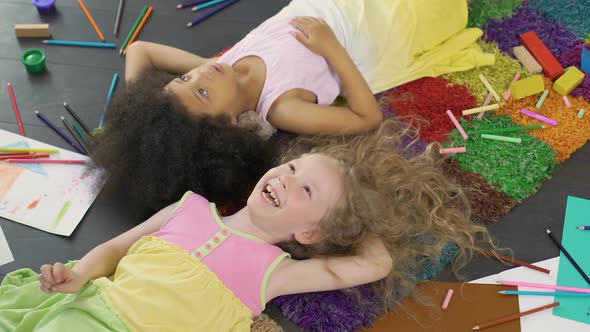 Best Friends Lying on Colorful Carpet and Laughing, Enjoying Cool Holidays