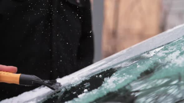 Person Hand Cleans Automobile Windshield From Icicles