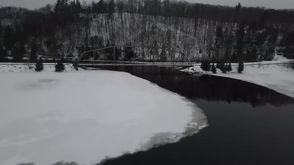 Drone video of antique steel truss bridge in the winter.