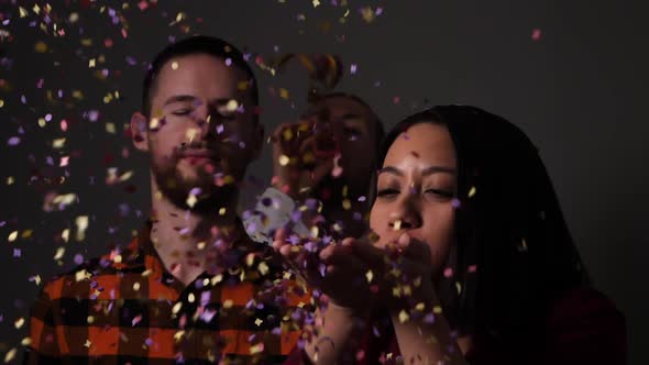 Group of friends start a party with confetti and serpentine streamers - Slow motion