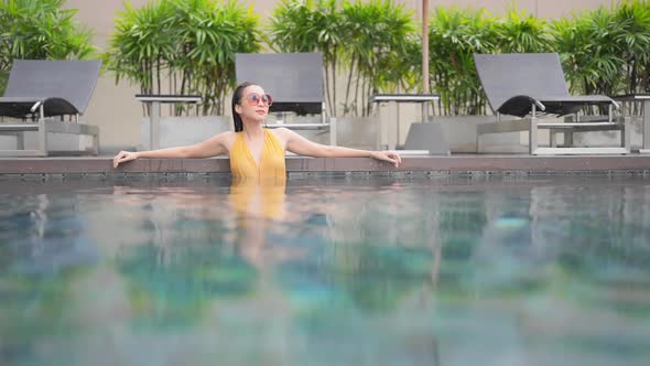 Young asian woman enjoy around outdoor swimming pool for leisure