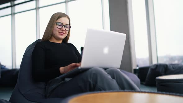 Young beautiful woman with glasses working on laptop.