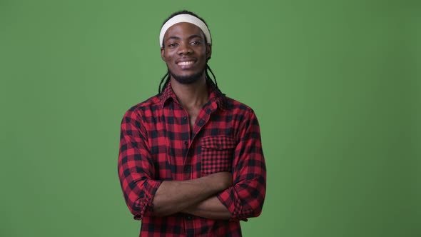 Young Handsome African Man with Dreadlocks Against Green Background