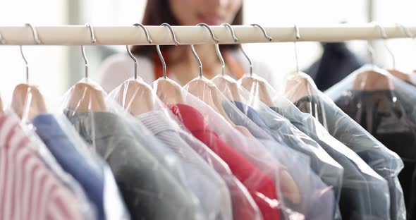 Woman Sorting Clothes in Plastic Bags on Hangers in Dry Cleaning Closeup  Movie Slow Motion