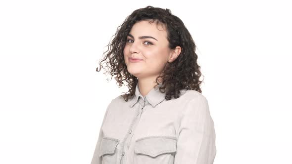 Portrait of Gorgeous Curly Woman with Round Face Posing with Flirting Look and Expressing