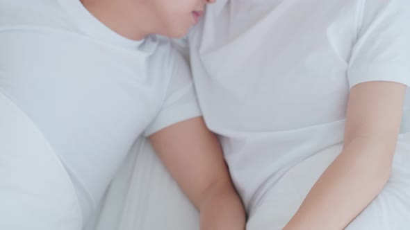 Asian young male gay family lying down on bed and look at each other.