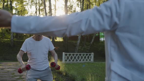 Training of Old Bearded Man in the Park with Doctor