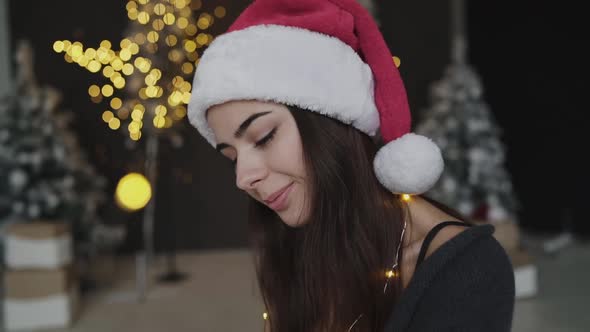 Hot Brunette in New Year's Hat and Lingerie Thoughtfully Looks at Camera