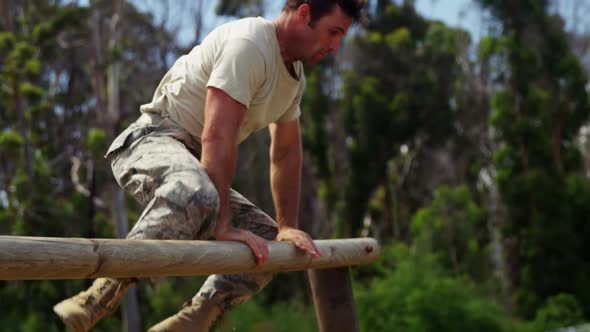 Military solider running over hurdles during obstacle course 4k