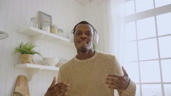 Cheerful Man Listens to Music Singing Alone in Kitchen