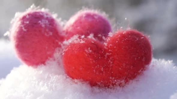 Valentine's Woolen Toy Hearts on the Snow and Backlighted By Winter Morning Sun