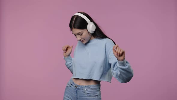 Portrait of a Model with Natural Beauty Enjoying Music in Big Wireless White Headphones