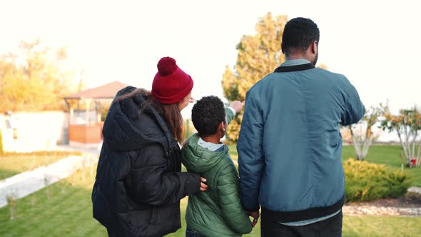 Back view of an African family pointing with finger on the terrace