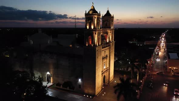 Aerial pushes in close to bell tower with nighttime view of the Cathedral de San Gervasio in Vallado