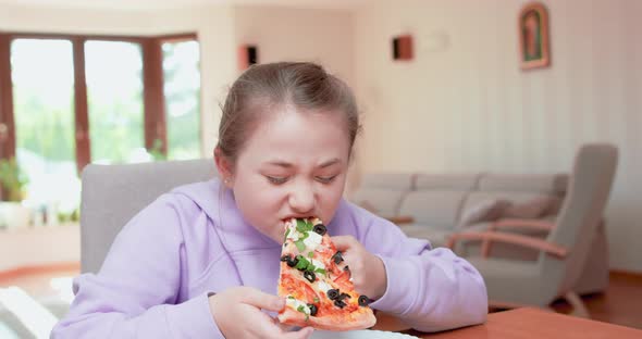 Teen Girl Eats Tasty Pizza Slice From Plate in the Livingroom