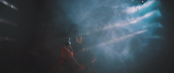 Blurry view of man recording with vintage camera surrounded by smoke