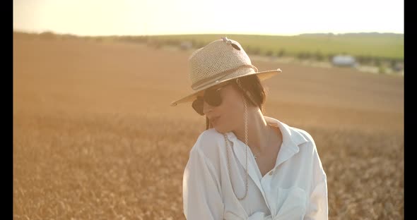 Beautiful Brown Hair Young Woman on Summer Wheat Field