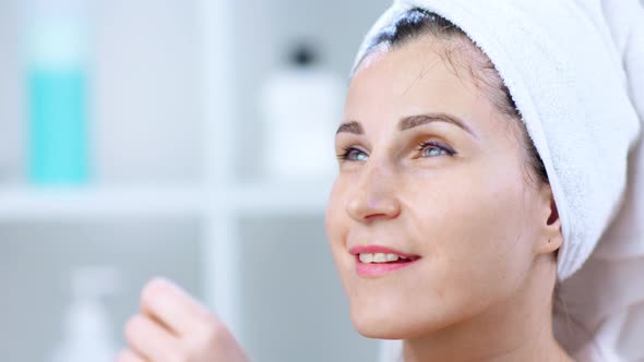 Portrait of Happy Young Woman Removing Cosmetic Mask From Face After Procedure