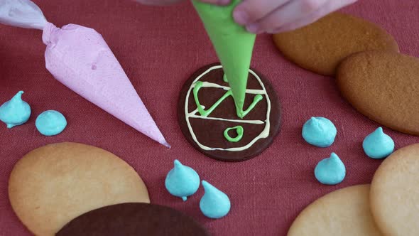 Child is decorating a cookie with multicolored icing