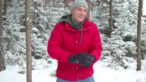 Man in Winter Gloves Sculpts a Snowball. Medium Shot