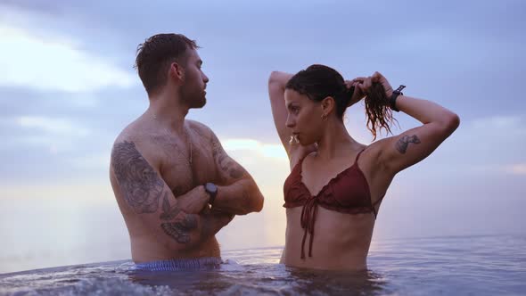 Couple Standing at an Infinity Pool in the Backdrop of Gleaming Sunset