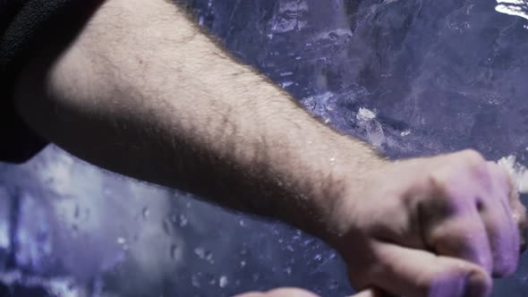 Professional Artist is Carving the Ice with a Knife to Make a Sculpture