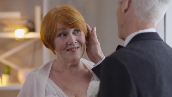 Happy Redhead Senior Bride Smiling As Groom Touching Hair in Slow Motion