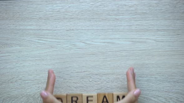 Dream, Hand Pushing Word on Wooden Cubes, Possibilities, Motivation and Goals