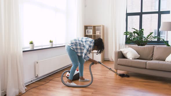 African American Woman with Vacuum Cleaner at Home