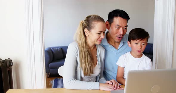 Happy family using laptop in living room