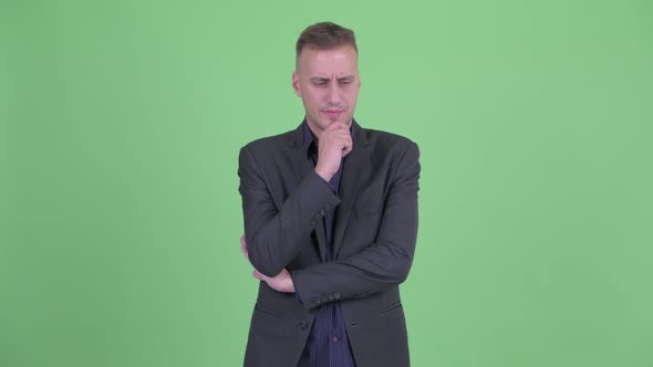 Stressed Businessman in Suit Thinking and Looking Down