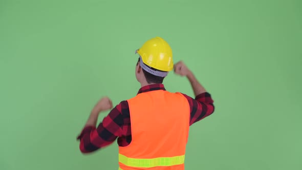Rear View of Happy Young Multi Ethnic Man Construction Worker with Fists Raised