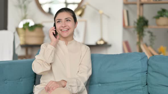 Indian Woman Talking on Smartphone on Sofa 