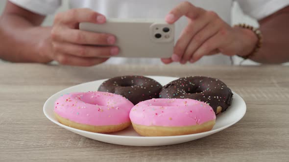 Unrecognizable Man Photographs Donuts on a Smartphone