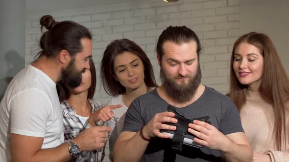Bearded Man Using Virtual Reality Glasses with His Friends