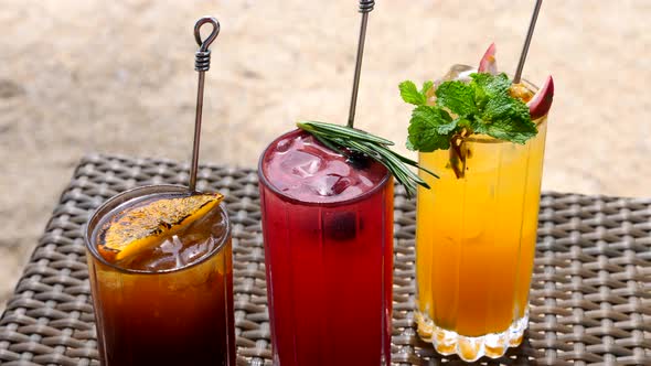 Set of Refreshing Fruit Cocktails Standing on Table on Beach Near Turquoise Sea