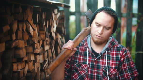 Young Man Woodcutter with Ax Standing in Front of the Camera