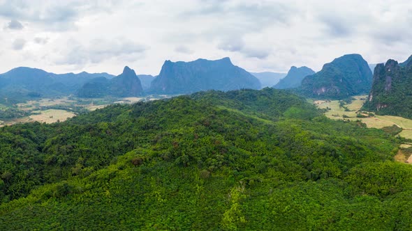 Aerial: panorama of scenic cliffs rock pinnacles tropical jungle rice paddies