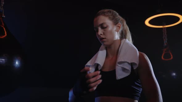 Portrait of the Boxer Woman Binds Hand Bandage Before the Training Standing in the Boxing Gym