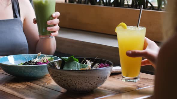 Closeup of Two Women Having Vegan Lunch in Cafe